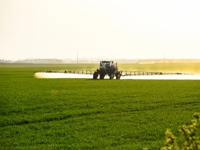 Tractor spraying fertilizer on a field